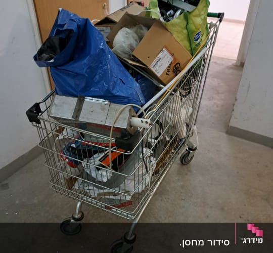 עגלת קניות מלאה בקרטונים ושקיות לארגון הבית